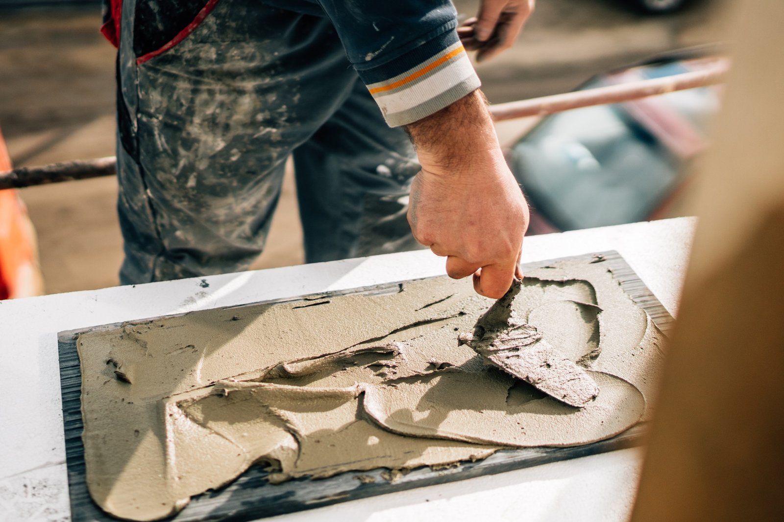 ceramic tiles. the worker's hand adding adhesive on marble, stone